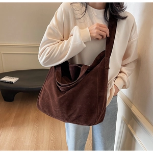 Detailed view of the large dark brown suede tote bag with a soft drape texture