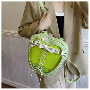 Detailed view of light green heart-shaped ita bag with clear window and bow decoration