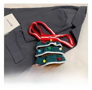 Détail d'un sac en tricot artisanal en forme de sapin de Noël avec pompons colorés