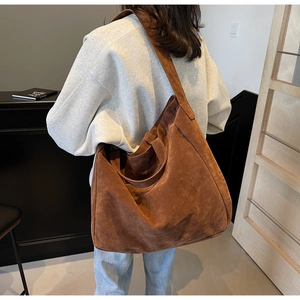 Detail of caramel brown suede hobo tote showing large capacity and soft texture