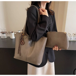 Brown leather tote bag and zipper pouch set with decorative braided charm detail