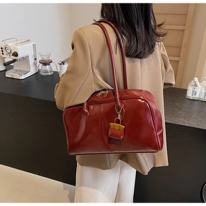 Deep red patent PU leather tote bag with double handles and mini charm in cafe setting