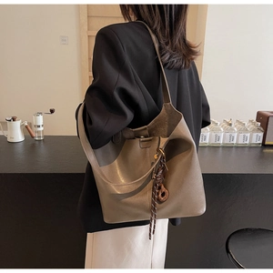 Mocha brown PU leather tote bag with silk scarf detail worn by a model in a cafe setting