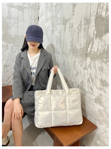 Urban lifestyle shot of a large white quilted tote bag with soft padded puffy square pattern