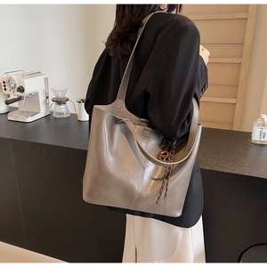 Chic taupe PU leather tote bag with vertical stitching and wooden ring pendant detail