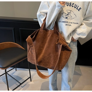 Detailed view of deep brown suede tote bag showing its premium matte texture and wide strap