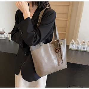 Detail of taupe PU leather tote bag with unique key and wood ring charm decoration