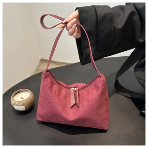 Detailed macro view of burgundy suede hobo bag featuring premium texture and double zippers