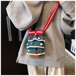 Détail du sac à bandoulière tricoté en forme de sapin de Noël avec pompons et nœud