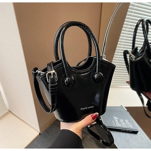 Glossy black patent leather bucket bag with top handle and adjustable shoulder strap