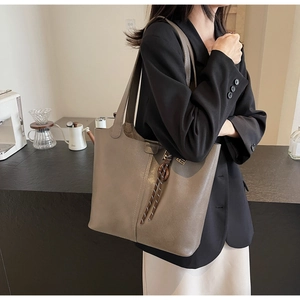 Detail of taupe PU leather tote bag with braided knot tassel and matte leather texture