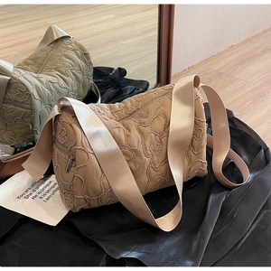 Khaki quilted bucket bag with floral embroidery and wide canvas shoulder strap
