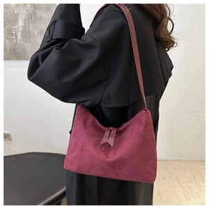 Chic burgundy suede tote bag with fringe zippers shown from a stylish side view angle