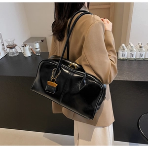Chic black glossy PU leather tote bag shown on a model in a minimalist cafe setting