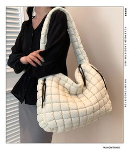 Detail van witte gewatteerde bubble shopper met zachte textuur en zwarte trekkoorden