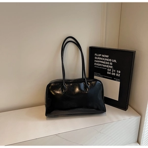 Glossy black PU leather rectangular handbag with long handles on marble surface