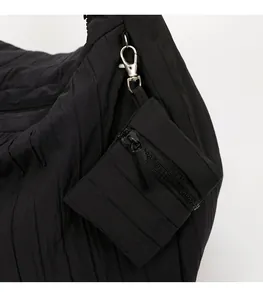Detail of black quilted fabric texture with silver metal hook and mini zipper pouch