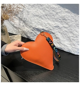 Détail de la pochette coeur en cuir PU orange avec sangle brodée de lettres LOVE