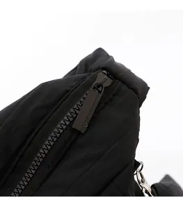 Close-up of black smooth zipper and matte metal puller on waterproof nylon shoulder bag