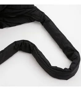 Detail of wide padded shoulder strap on black quilted puffy bag with smooth zipper