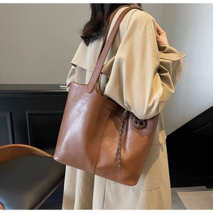 Chic caramel brown PU leather tote bag styled on model for everyday office commute
