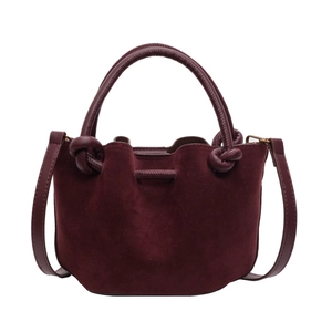 Vintage burgundy suede bucket bag with woven knot handles and adjustable crossbody strap