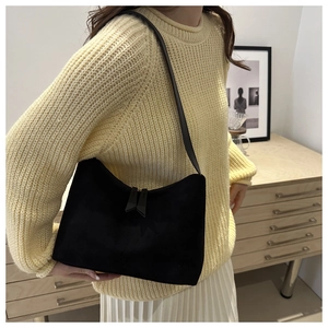 Detail of minimalist black suede underarm bag with double zipper and leather strap