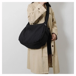 Detail showing the pleated texture and wide shoulder strap of black large canvas bag