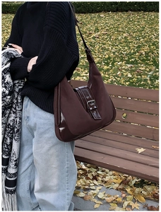 Detail of vintage chocolate brown tote bag with leather buckle and matte texture