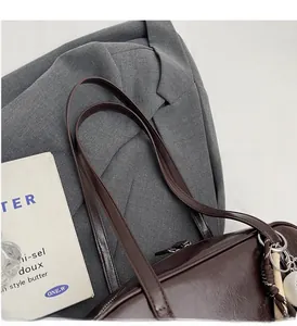 Détail de la poignée du sac en cuir PU marron foncé avec pendentif tressé élégant