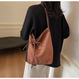 Detail showing vintage brown matte suede tote bag with a side decorative bow knot