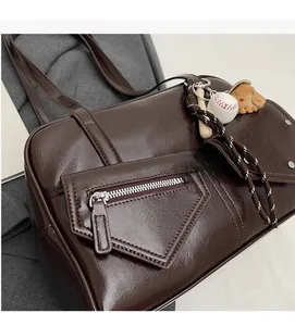 Détail du sac Boston en cuir PU marron foncé avec pendentif baseball et poche latérale