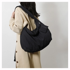 Detail of black quilted shoulder bag with soft textured nylon and matching small side pouch