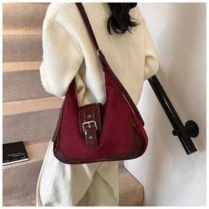 Detail of vintage burgundy tote bag featuring matte suede textures and silver buckle details