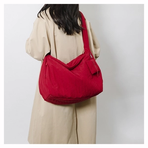 Detail of red quilted canvas tote bag with a small matching zip pouch for extra storage
