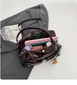 Vue intérieure du sac à bandoulière en similicuir marron montrant une grande capacité
