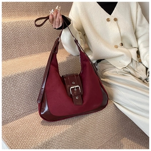 Detail of burgundy hobo bag showing matte suede texture and shiny faux leather panels