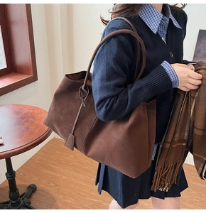 Close-up of chocolate brown suede tote bag featuring matte finish and slim shoulder straps