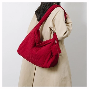 Detail of red pleated nylon shoulder bag showing texture and matching mini coin purse