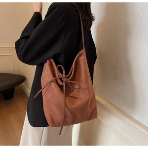 Detail of vintage brown nylon tote bag with decorative side bow knot shown on model
