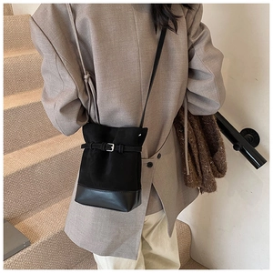 Detail view of black drawstring bucket bag with frosted suede and smooth leather textures