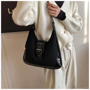 Detail of black crescent hobo bag featuring mixed leather fabric and metal buckle strap