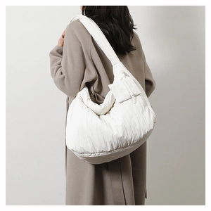 Detail of white quilted puffer shoulder bag with a matching small hanging zipper coin purse