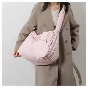 Close-up of pink quilted cloud bag featuring vertical pleats and metal zipper pocket