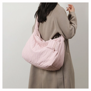 Detail of pink pleated puffer tote bag with small zip pouch shown on fashion model