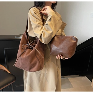 Detail of brown nylon tote bag set with decorative bow and matching pouch for women