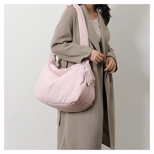 Detailed view of a large pink quilted tote bag with a matching mini coin purse