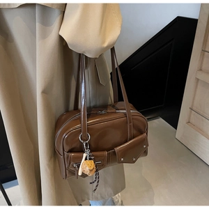 Sac bandoulière marron en PU brillant avec poches et breloque porté avec un trench