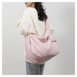 Detail of pink pleated canvas tote bag with wide strap and matching small zipper pouch