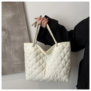 Détail d'un sac cabas blanc matelassé avec coutures losanges et poignée en corde